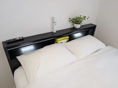 a bed with a black headboard with two white pillows at MerisuKabukicho,Tokyo in Tokyo