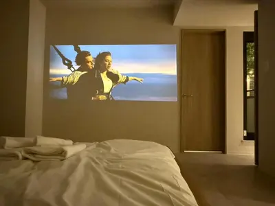 a bedroom with a large tv hanging on the wall at \u6e0b\u8c37\u672c\u753a\u30db\u30c6\u30eb in Tokyo