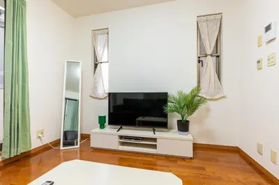 a living room with a flat screen tv sitting on a cabinet at Shinjuku Newly renovated 4LDK House! in Tokyo