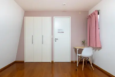 a room with white cabinets and a table and a pink curtain at Shinjuku Newly renovated 4LDK House! in Tokyo