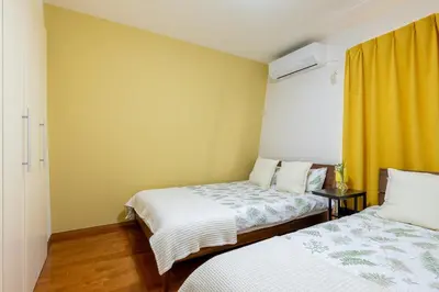 a bedroom with two beds and a yellow curtain at Shinjuku Newly renovated 4LDK House! in Tokyo