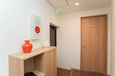 a room with a table with a vase and a door at Natsumi\u30db\u30c6\u30eb \u9ad8\u7ea7\u72ec\u680b\u522b\u5885301 in Tokyo