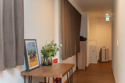 a hallway with a table with a picture and flowers on it at Natsumi\u30db\u30c6\u30eb \u9ad8\u7ea7\u72ec\u680b\u522b\u5885301 in Tokyo