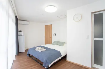 a bedroom with a bed and a clock on the wall at Natsumi\u30db\u30c6\u30eb \u9ad8\u7ea7\u72ec\u680b\u522b\u5885301 in Tokyo