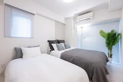 a bedroom with two beds and a potted plant at LIVCITY Kinshicho 1202 Skytree view in Tokyo