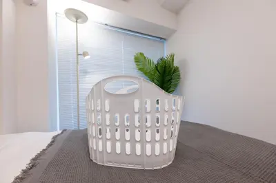 a white chair sitting on a bed in a room at LIVCITY Kinshicho 1202 Skytree view in Tokyo