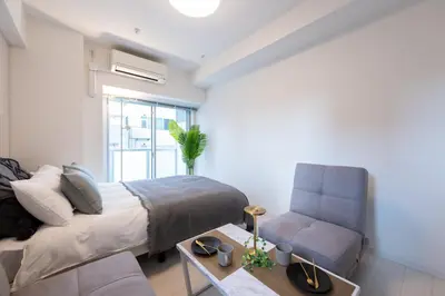 a bedroom with a bed and a couch and a chair at LIVCITY Kinshicho 1202 Skytree view in Tokyo