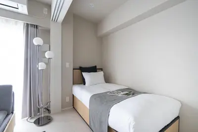 a small bedroom with a bed and a window at \u30a2\u30fc\u30d0\u30cd\u30c3\u30af\u30b9\u99d2\u8fbc in Tokyo