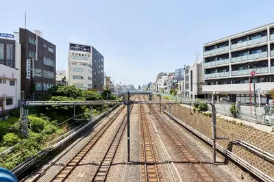 a group of train tracks in a city with buildings at \u30a2\u30fc\u30d0\u30cd\u30c3\u30af\u30b9\u99d2\u8fbc in Tokyo