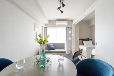 a living room with a table and chairs and a bed at \u30a2\u30fc\u30d0\u30cd\u30c3\u30af\u30b9\u99d2\u8fbc in Tokyo