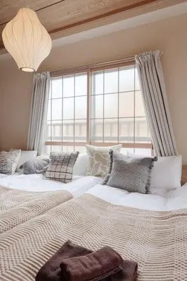 two beds in a bedroom with a large window at LINKAGE STAY Shinagawa Tachiaigawa in Tokyo