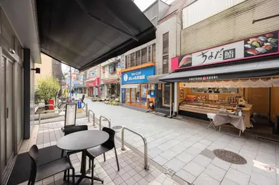 an empty street with a table and chairs on a sidewalk at LINKAGE STAY Shinagawa Tachiaigawa in Tokyo