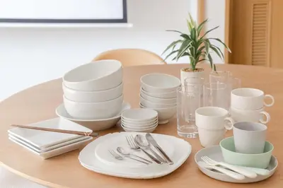 a table with white plates and silverware on it at LINKAGE STAY Shinagawa Tachiaigawa in Tokyo