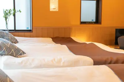 a large white bed in a room with two windows at Nestry \u6d45\u8349 yuuan Fuji 202 in Tokyo