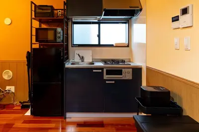 a kitchen with a black refrigerator and a sink at Nestry \u6d45\u8349 yuuan Fuji 202 in Tokyo