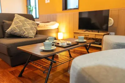 a living room with a couch and a coffee table at Nestry \u6d45\u8349 yuuan Fuji 202 in Tokyo