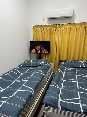 a bedroom with two beds and a tv on the wall at Miaoyi Shinokubo in Tokyo