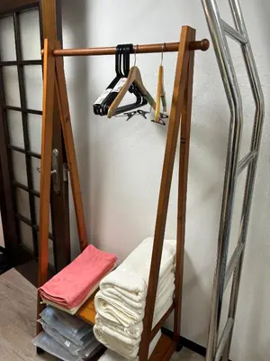 a ladder shelf with towels on it next to a wall at Miaoyi Shinokubo in Tokyo