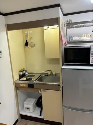 a small kitchen with a sink and a microwave at Miaoyi Shinokubo in Tokyo