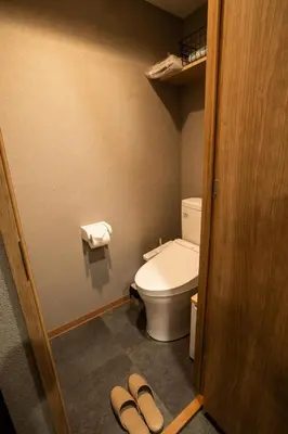 a bathroom with a toilet and a pair of slippers at Nestry Asakusa 302\u53f7\u5ba4 in Tokyo