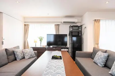 a living room with two couches and a flat screen tv at Nestry Asakusa 502\u53f7\u5ba4 in Tokyo