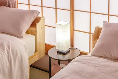 a bedroom with two beds and a table with a lamp at 1200IN&OUT 10people 75m2 8bed! Exclusive house Shinjuku 13 minutes Shibuya 19 minutesIkebukuro 8 minutes Ueno 9 minutes in Tokyo
