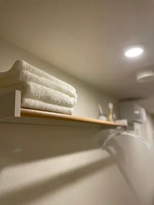 a towel on a wooden shelf in a bathroom at T-Hotel\u5165\u8c37 in Tokyo
