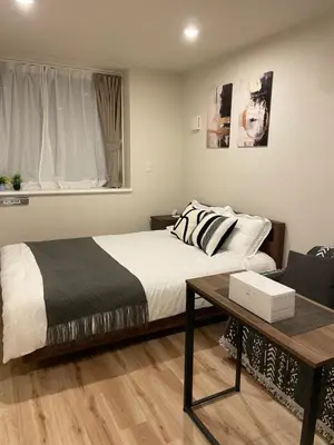 a bedroom with a bed and a table and a window at T-Hotel\u5165\u8c37 in Tokyo