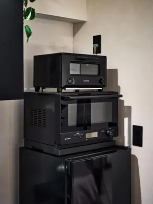 a microwave and a toaster oven on top of a printer at shibuya donkey stay in Tokyo