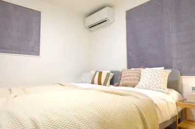 a bedroom with a bed and a air conditioner at New Garfieldhome Shinjuku in Tokyo