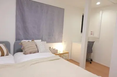 a white bedroom with a bed and a window at New Garfieldhome Shinjuku in Tokyo