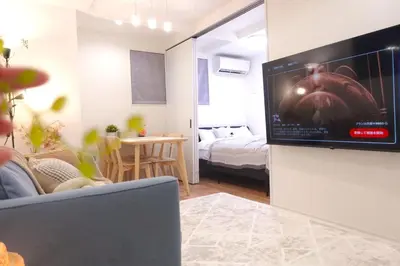 a living room with a flat screen tv on a wall at New Garfieldhome Shinjuku in Tokyo