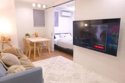 a living room with a flat screen tv on a wall at New Garfieldhome Shinjuku in Tokyo