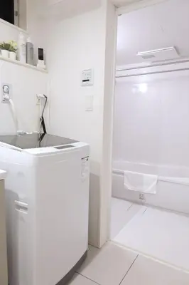 a white bathroom with a sink and a shower at New Garfieldhome Shinjuku in Tokyo