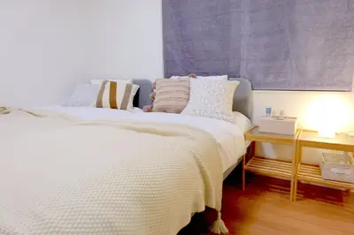 a bedroom with a white bed with pillows on it at New Garfieldhome Shinjuku in Tokyo