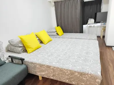two beds with yellow pillows in a room at Z HOME - Self Check in in Tokyo