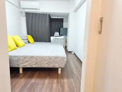 a bedroom with a bed with yellow pillows on it at Z HOME - Self Check in in Tokyo