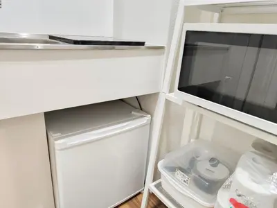 a small white refrigerator with its door open at Z HOME - Self Check in in Tokyo