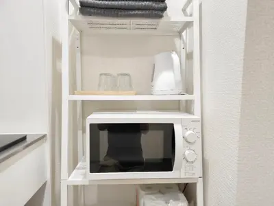 a microwave on a shelf in a kitchen at Z HOME - Self Check in in Tokyo