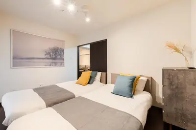 two beds in a room with white walls at \u30db\u30c6\u30eb\u5bcc\u58eb\u898b\u30de\u30f3\u30b7\u30e7\u30f3 in Tokyo