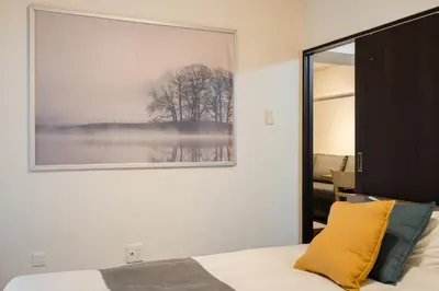 a bedroom with a large picture on the wall at \u30db\u30c6\u30eb\u5bcc\u58eb\u898b\u30de\u30f3\u30b7\u30e7\u30f3 in Tokyo