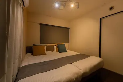 a bedroom with a large bed with yellow and green pillows at \u30db\u30c6\u30eb\u5bcc\u58eb\u898b\u30de\u30f3\u30b7\u30e7\u30f3 in Tokyo