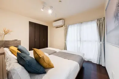 a bedroom with two beds and a window at \u30db\u30c6\u30eb\u5bcc\u58eb\u898b\u30de\u30f3\u30b7\u30e7\u30f3 in Tokyo