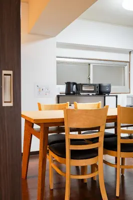 a kitchen with a wooden table and chairs at \u30db\u30c6\u30eb\u5bcc\u58eb\u898b\u30de\u30f3\u30b7\u30e7\u30f3 in Tokyo