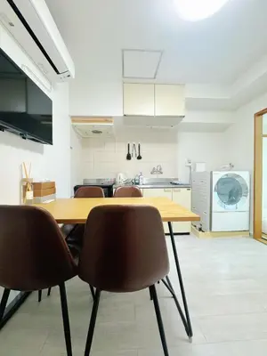 a kitchen with a wooden table and chairs at LoveAsakusa Stay 6 Iriya Station Ueno Station 2\u30fc6\u4eba \u30a8\u30ec\u30d9\u30fc\u30bf\u30fc WIFI \u6d45\u8349 \u65b0\u5bbf \u6e0b\u8c37 \u9280\u5ea7 \u7bc9\u5730 \u6d45\u8349 \u539f\u5bbf\u8fd1\u3044 in Tokyo