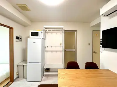 a room with a white refrigerator and a microwave at LoveAsakusa Stay 6 Iriya Station Ueno Station 2\u30fc6\u4eba \u30a8\u30ec\u30d9\u30fc\u30bf\u30fc WIFI \u6d45\u8349 \u65b0\u5bbf \u6e0b\u8c37 \u9280\u5ea7 \u7bc9\u5730 \u6d45\u8349 \u539f\u5bbf\u8fd1\u3044 in Tokyo