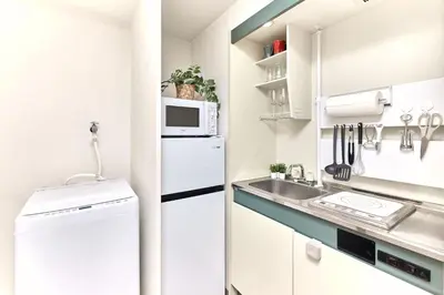 a white kitchen with a sink and a refrigerator at Quiet TOKYO Stay Kami-kitazawa in Wada