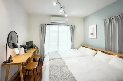 a bedroom with a bed and a desk and a window at Quiet TOKYO Stay Kami-kitazawa in Wada