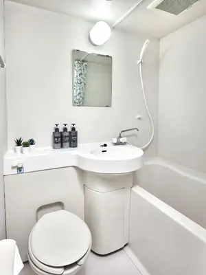 a white bathroom with a toilet and a sink at Quiet TOKYO Stay Kami-kitazawa in Wada