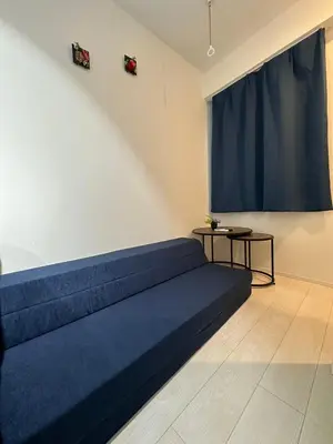 a room with a blue bed with a blue curtain at \u65b0\u7bc9OPEN GREW OJI residence202 in Tokyo